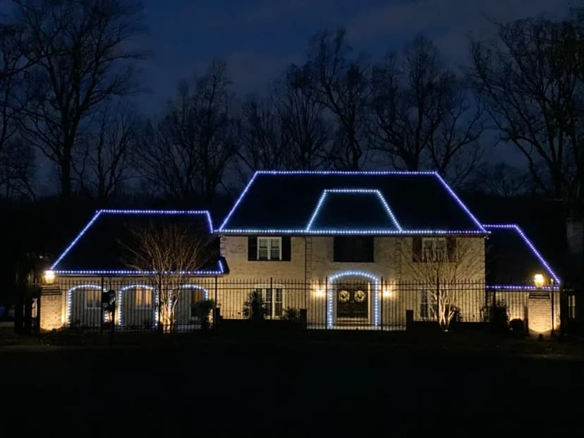 Christmas light installation in the DMV — cool white roofline on an estate home