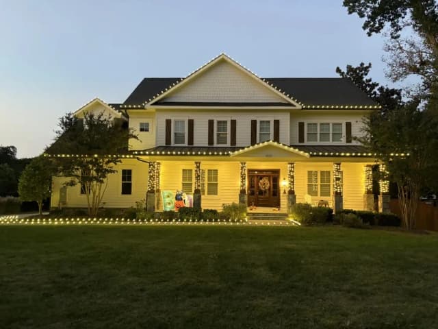 Christmas light installation in the DMV — warm white roofline on a colonial home