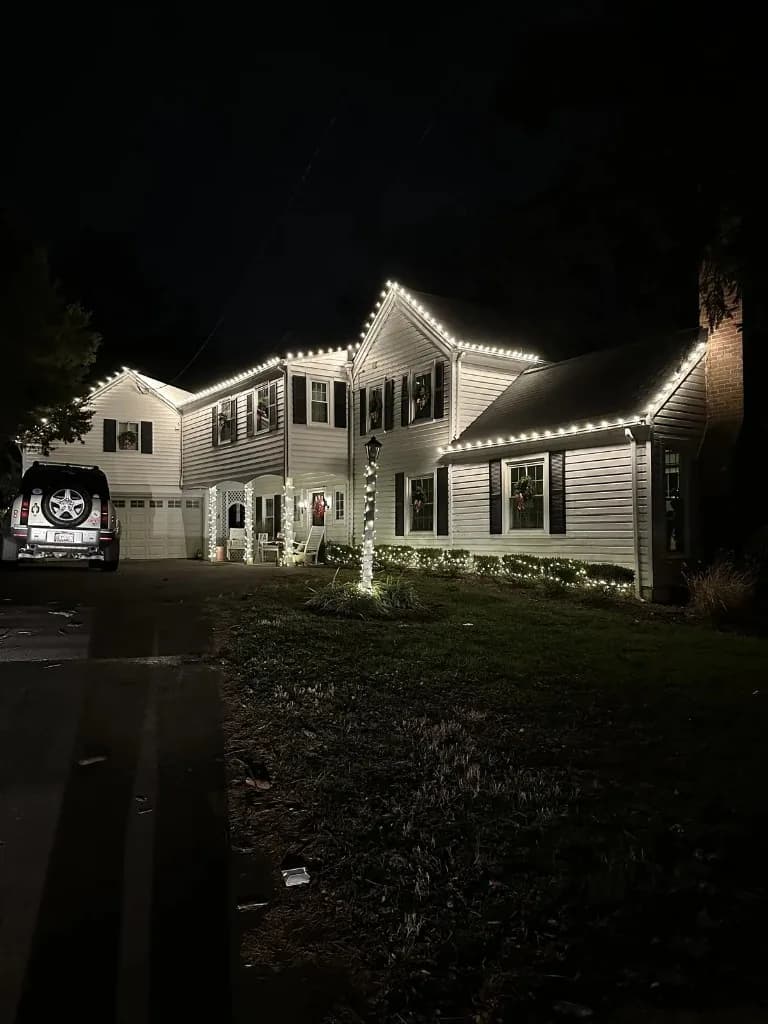Christmas light installation in the DMV — warm white roofline on a suburban home at night