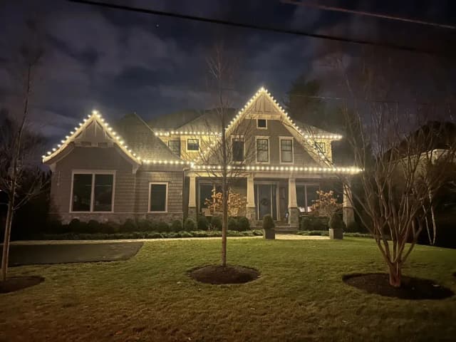 Christmas light installation in the DMV — bright warm white holiday roofline