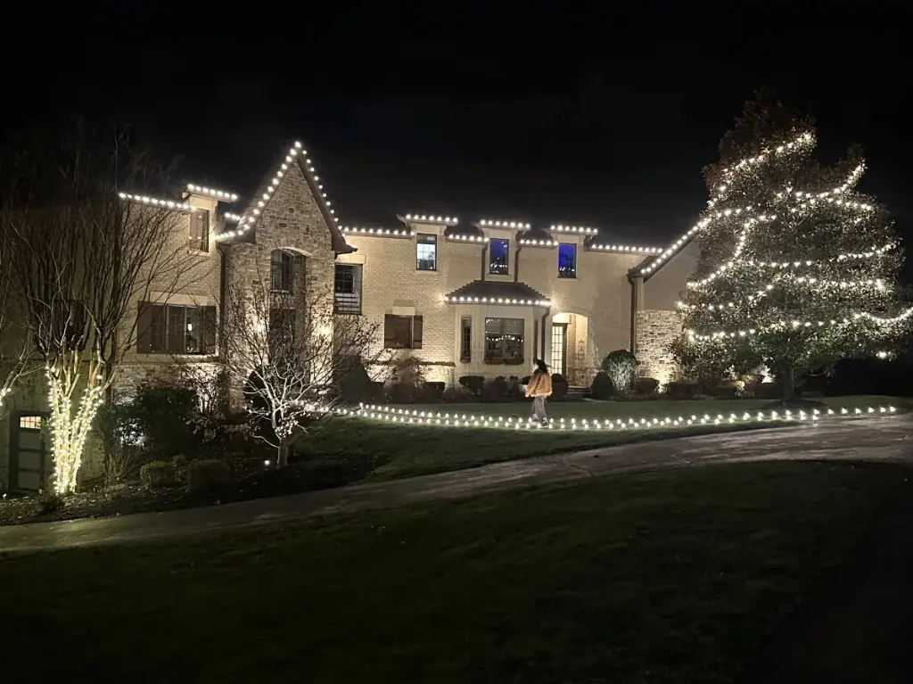 DMV home at night — warm white roofline, tree wraps & lit pathway — LightDMV