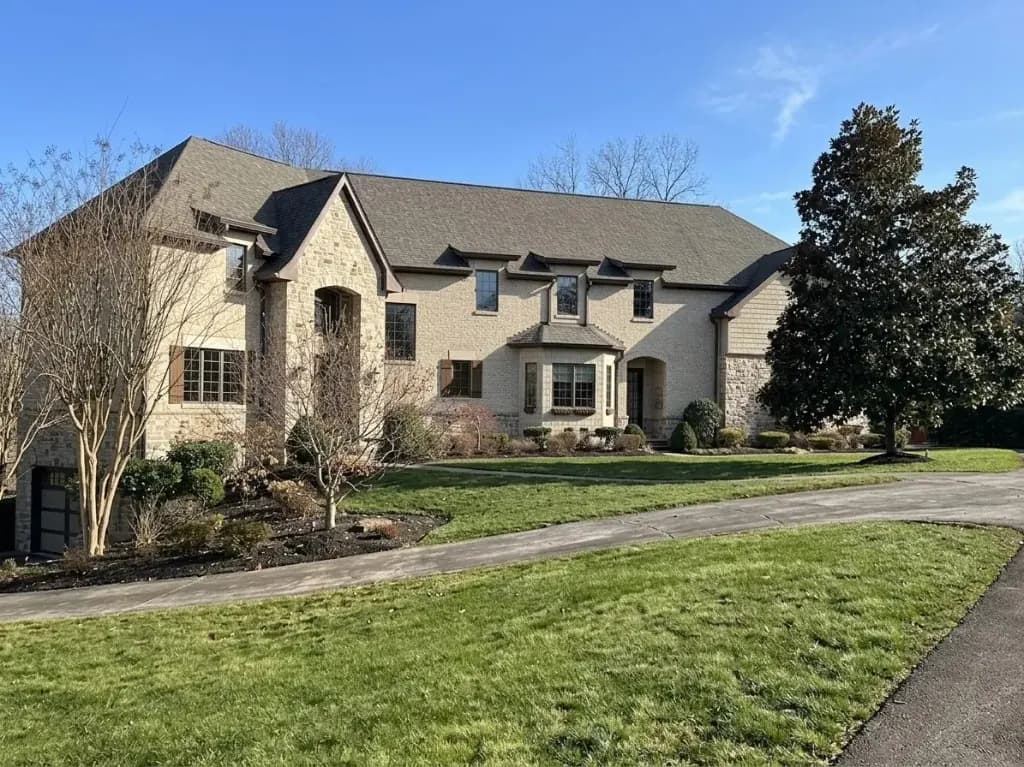 Same stone-and-stucco DMV home by day, before holiday lighting — LightDMV