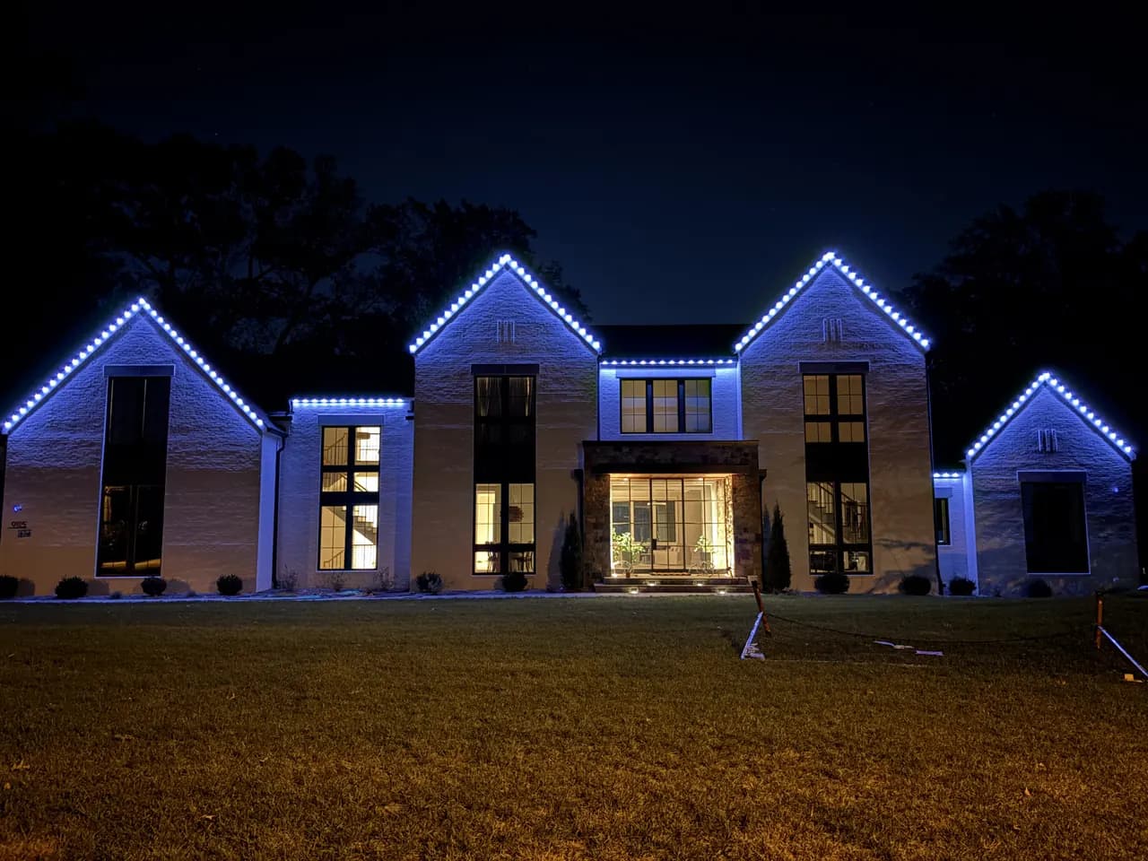 Permanent LED roofline lighting on a Vienna, VA home — warm white at night