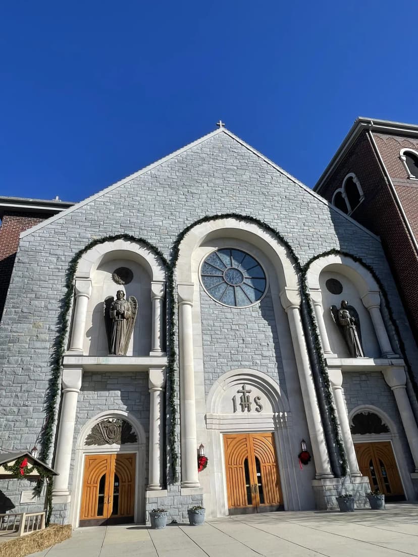 Commercial garland and wreath install on a stone church facade — LightDMV